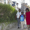 Two women and a young girl walking together through a residential neighborhood in North Philadelphia.