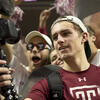A student taking video of himself at a basketball game.