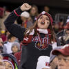a fan in the crowd wearing Temple gear, cheering on the Temple football team.