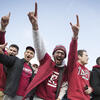 A group of students cheering at a Temple football game.