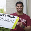 Chey Jones holding a sign for his next stop, Stanford University.