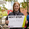 Amelia Schunder holding up a sign that says Next Stop: Lyon, France