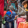 Woman handing candy to a little boy in costume during Avenue of Treats event
