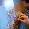 a student placing a pin on a world map