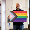 Jason Levy holding the Progress Pride flag