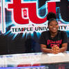 A teenage girl sitting at the anchor desk at TUTV