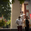 Image of two students wearing face coverings walking down Polett Walk on Main Campus.