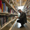 Image of student looking through bookshelves at Charles Library.