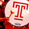 Student playing a drum with a T on it