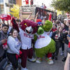 A group of smiling Temple students wearing red shirts and waving Red October towels celebrate the Philadelphia Phillies.