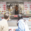 Image of students interviewing a food truck operator.