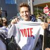 A Temple student holding a t-shirt that says vote