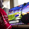 Image of a student wearing a Temple esports jersey playing a PC game.