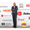 Joydeep Srivastava pictured behind a white wall with tons of brand logos.