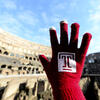 A hand wearing a Temple glove in front of the Colosseum in Rome.
