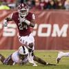 A Temple football player dodging a tackle in the game against UConn.