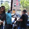 A woman in a Temple T-shirt smiling as she unpacks a car during move in.