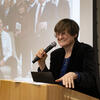 Dr. Kariko standing and speaking at a podium