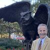 Dave Deveraux stands next to the Owl statue on Temple's main campus.