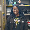A headshot photo of Kaylah Chambers. She is standing in the TFR workshop.