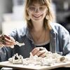 Inside the Cordes Laboratory, Eva Close, Class of 2027, looks through her self-made porcelain corals, which she created through Temple’s Diamond Research Scholars Program. 