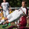 A Temple men's soccer player kicking the ball during a match.