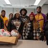 A group of men and women standing in front of a box of turkeys around Thanksgiving at Temple.