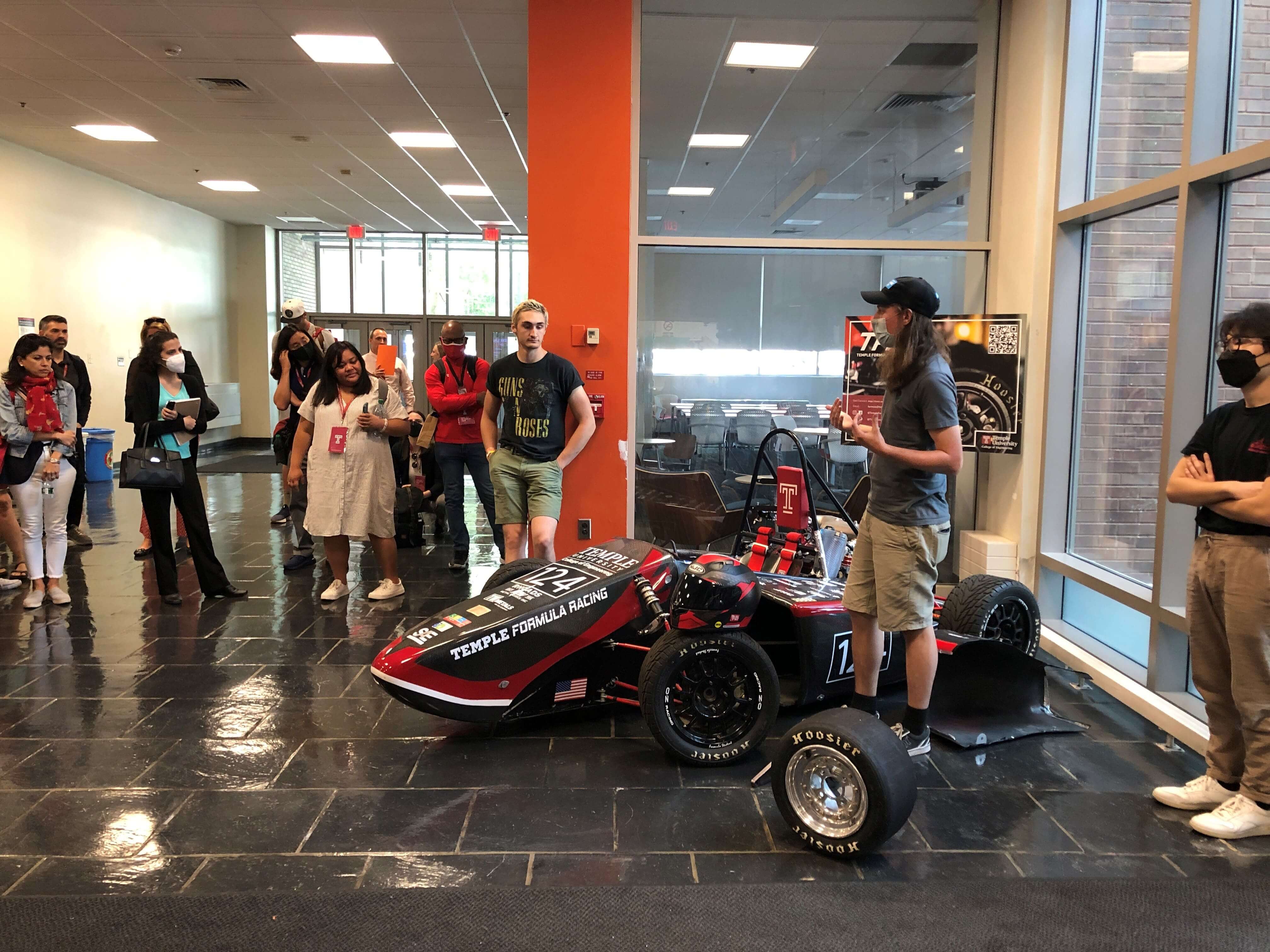 Image of Temple Formula Racing students showing others their 2018 race car.
