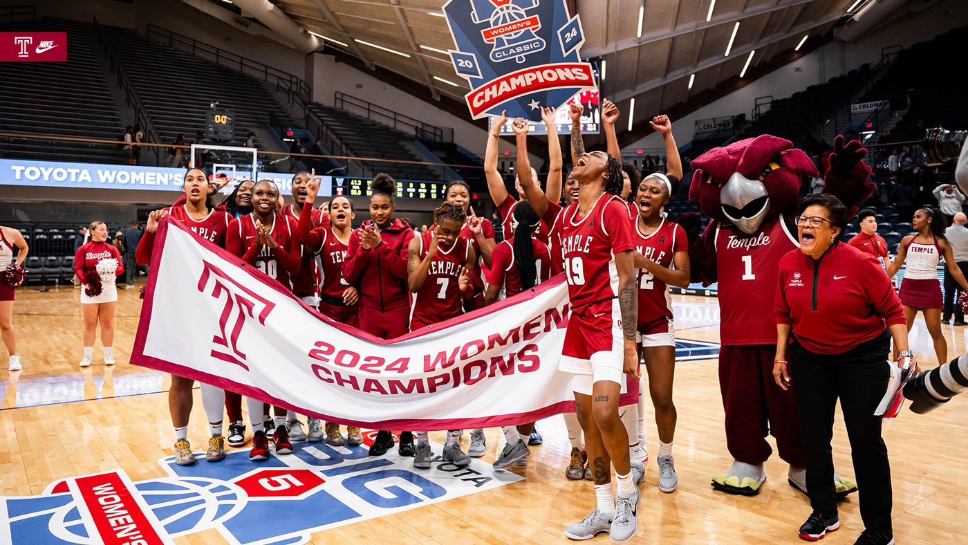 Image of Temple women s basketball in the cherry and white celebrating on the court.
