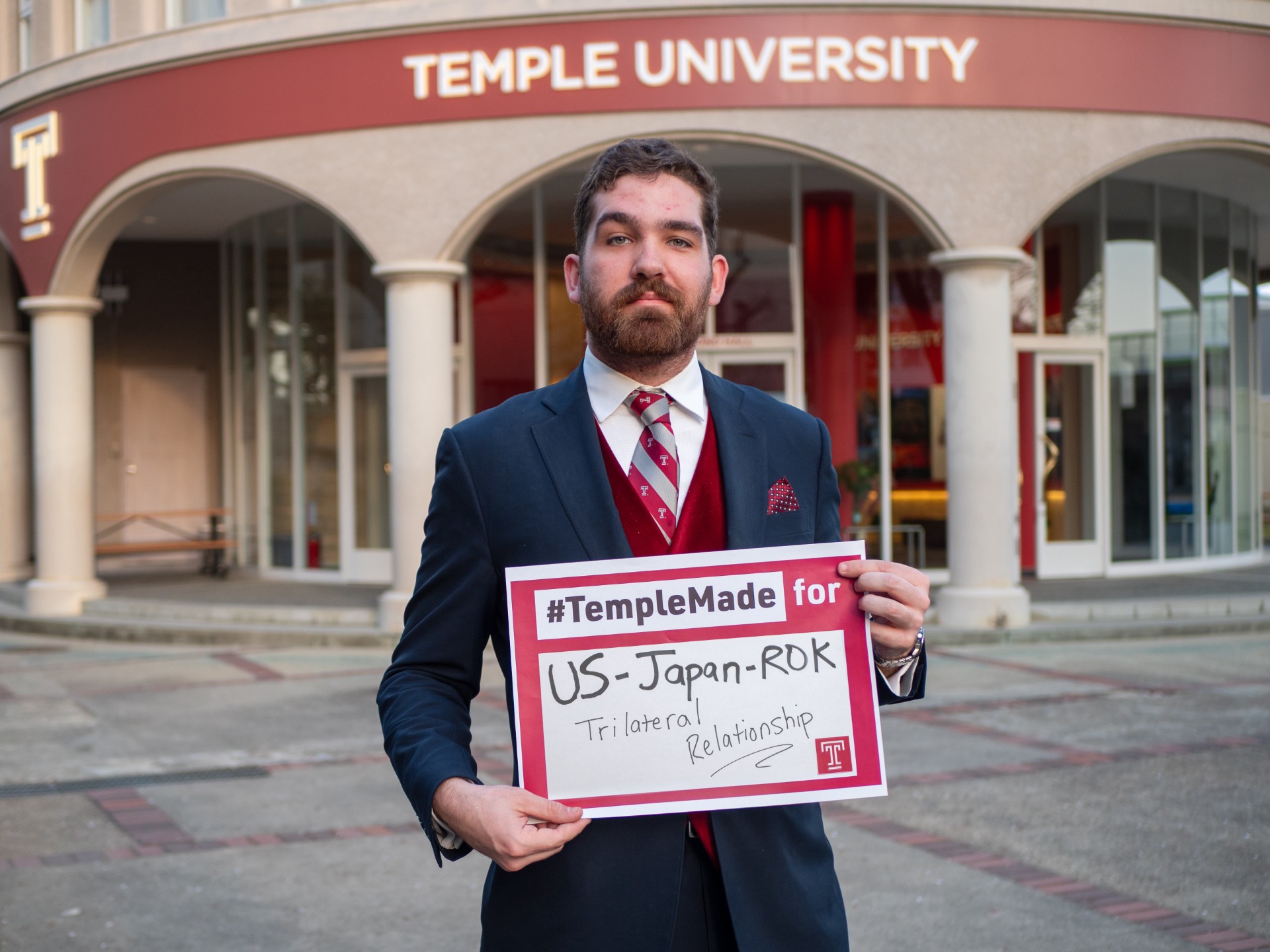 Soren holds sign saying #TempleMade for US-Japan-ROK Trilateral Relationship