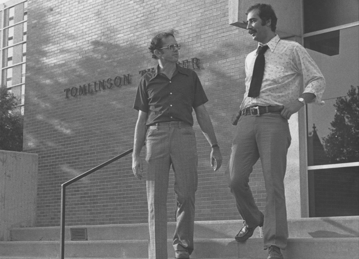 Image of two people walking down the steps of Tomlinson Theater.