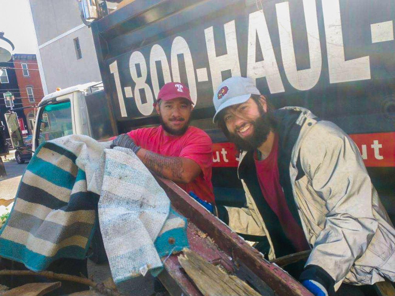 Image of two men wearing Temple branded hats in front of truck